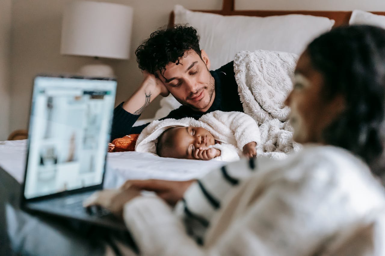 A loving family scene with parents and a baby in a cozy bedroom setting.